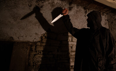 murderer with big knife and shadow horror scene