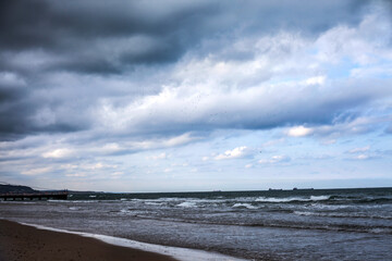 waves crashing on the beach ground shot and cloudy blue sky