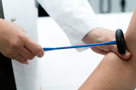The neurologist testing elbow reflex on a man patient using a hammer. Neurological physical examination. Orthopedist work. Orthopedic surgeon examining checks the physiological reflex test hammer.