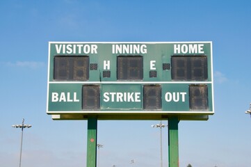 Baseball scoreboard green and white against blue sky