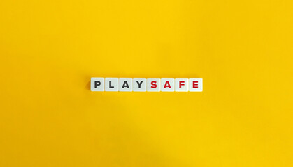 Play Safe Phrase on Block Letter Tiles on Yellow Background. Minimal Aesthetics.
