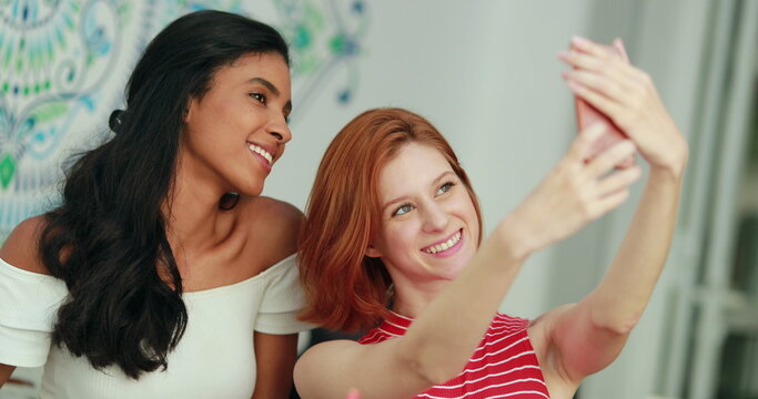 Pretty multiracial girls taking selfie with cellphone