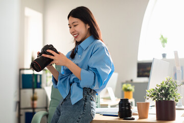 Happy Japanese Photographer Lady Holding Camera Standing At Workplace