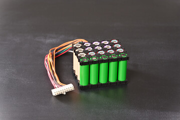 Lithium battery pack in black plastic holder on the dark background.