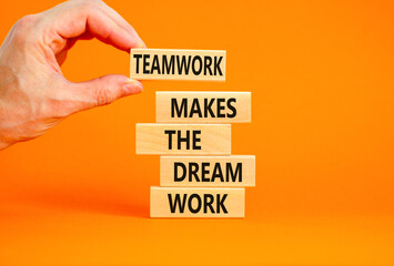 Teamwork makes dream work symbol. Concept words Teamwork makes the dream work on wooden blocks on beautiful orange background. Businessman hand. Business Teamwork makes dream work concept. Copy space.