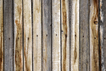 Siding made with the old and dirty wooden panels attached to the wall with rusty nails as a background