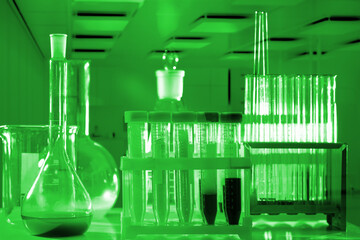 Laboratory flask. Test tubes on table. Test tubes for chemical research. Glass laboratory flasks. Lab test tubes in green light. Laboratory flask for science. Dishes for chemical experiments