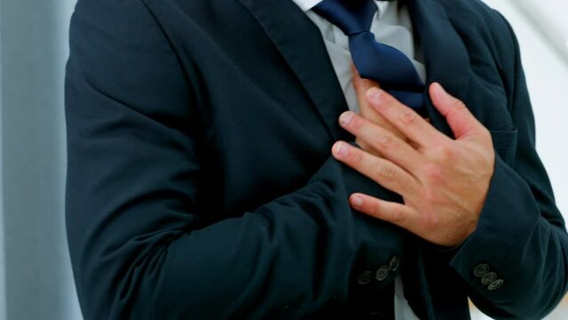 Cardio, pain and heart attack by business man in health crisis, state of emergency, holding chest in an office. Entrepreneur suffering an extreme, painful pressure from stress and unhealthy lifestyle