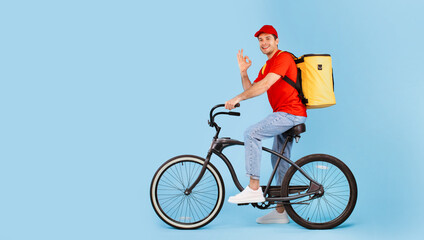 Deliveryman Riding Bike And Gesturing Okay On Blue Background