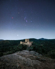 Medieval castle under Orion constellation and Rosette nebulae during a magical winter night in...