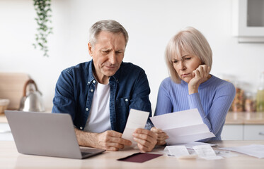 Confused elderly husband and wife checking their expenses