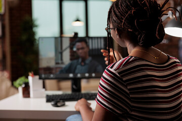 Woman talking with employee on videoconference, african american freelancer working from home....