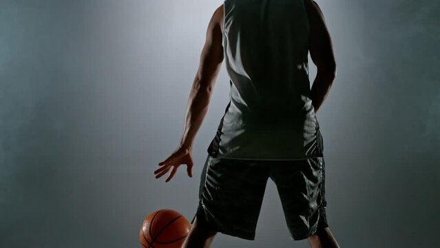 Super slow motion of basketball player dribbling. Filmed on high speed cinema camera, 1000fps. Speed ramp effect.