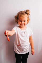 Close up portrait of little preschool age girl with brush in hand.