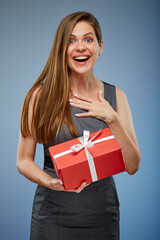 Surprising woman with red gift box studio isolated portrait on blue.