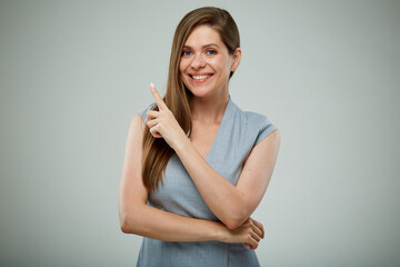 Woman in gray business dress pointing finger up. Isolated portrait.