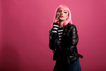 Portrait of attractive beautiful lady posing in front of camera, wearing trendy leather jacket to feel stylish and carefree. Female punk rocker with pretty fashion style having fun.