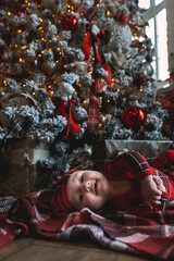 Obraz na płótnie Canvas Little boy celebrates christmas in a decorated room