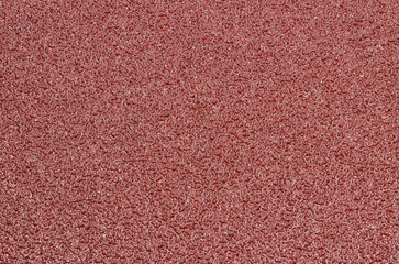 Background - red sandpaper with a clearly visible structure.