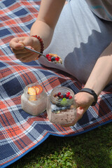 Obraz na płótnie Canvas Breakfast in a jar. Girl eating breakfast on a sunny day at a picnic