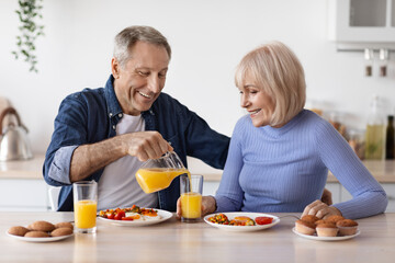 Obraz na płótnie Canvas positive healthy pensioners enjoying delicious breakfast together