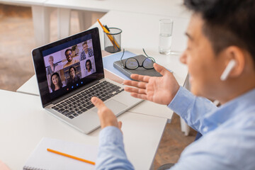 Fototapeta premium Japanese Male Teacher Video Calling Via Laptop Teaching Students Indoor