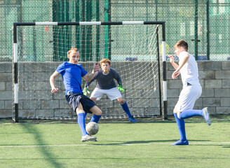 Youthful football players challenging for ball in midfield zone