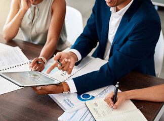 Finance, tablet and hands writing in a notebook during a meeting with team working in...