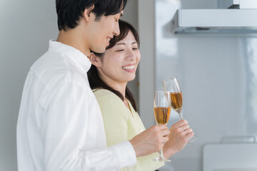 キッチンで乾杯する日本人夫婦