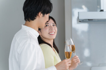 キッチンで乾杯する日本人夫婦