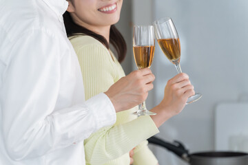 キッチンで乾杯する日本人夫婦