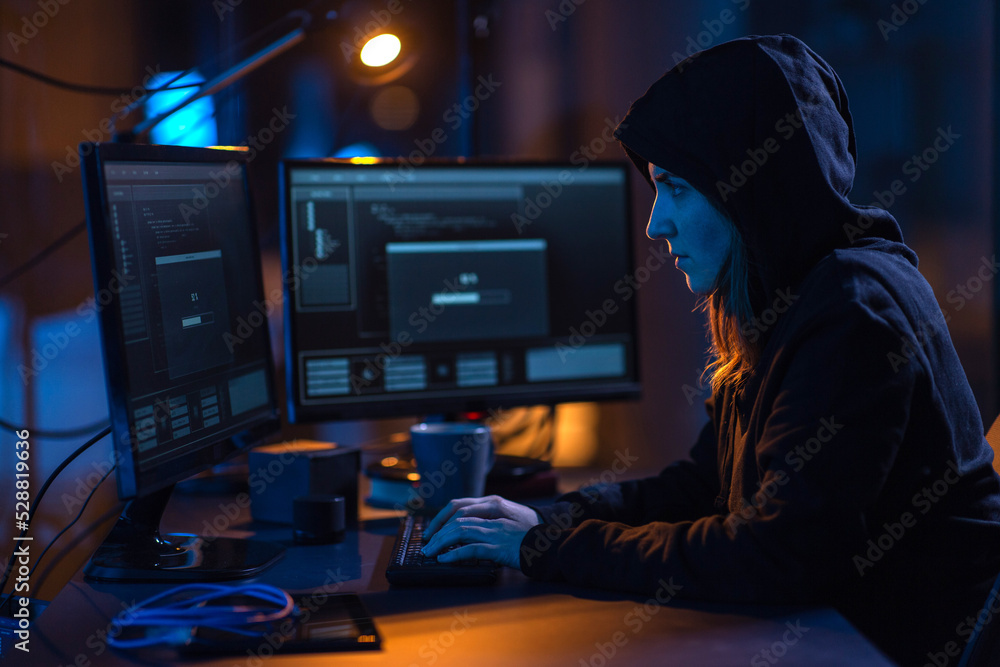 Poster cybercrime, hacking and technology concept - female hacker in dark room writing code or using comput