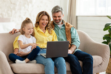 Happy Family Using Laptop Browsing Internet Together At Home