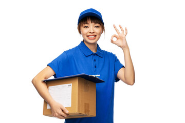 profession, job and people concept - happy smiling delivery woman in blue uniform holding parcel box showing ok gesture over white background