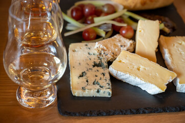 Pairing of scotch whisky and farmers scottish cheeses cheddar, stilton, blue cheese, brie, tasting of whiskey and cheese in Edinburgh, UK