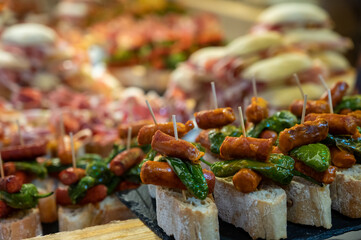 Typical snack of Basque Country and Navarre, pinchos or pinxtos, small piece of bread with different toppings, served in bar, Bilbao, Spain