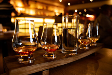 Flight of single malt scotch whisky in glasses served in whiskey bar in Edinburgh, UK