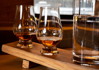 Flight of single malt scotch whisky in glasses served in whiskey bar in Edinburgh, UK