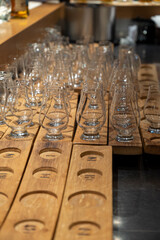 Emply whisky glasses served in flights on wooden boards in old whiskey bar in Edinburgh, UK