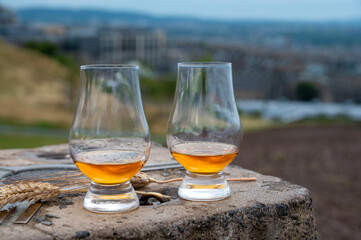 Tasting of single malt scotch whisky in glasses with view from Calton hill to new and old parts of Edinburgh city in rainy day, Scotland, UK