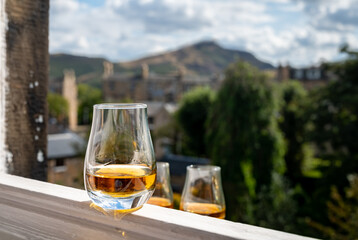 Glass of single malt scotch whisky served on old white window sill in Scottisch house with view on...
