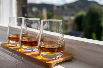 Flight of single malt scotch whisky served on old window sill in Scottisch house with view on old part of Edinburgh, Scotland, UK