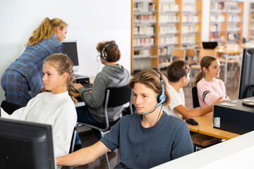Obraz premium Teenage student in headphones at the computer in a school class