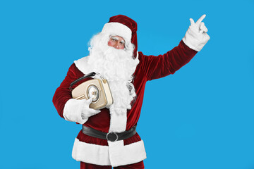 Fototapeta na wymiar Santa Claus with vintage radio on blue background. Christmas music