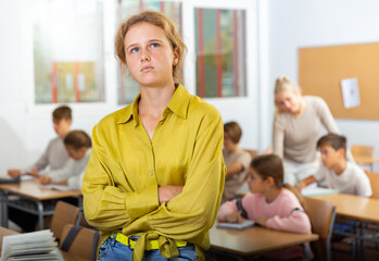 Stressed cute girl feeling upset after getting bad mark at secondary school in class room