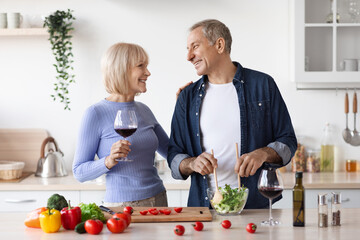 Loving senior couple celebrating anniversary, making dinner together