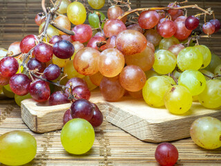 Green variety of grapes on the table. Berry harvest. Home furnishings. Kishmish on the table. Grapes of different colors. Fruit dessert. Wine ingredient.