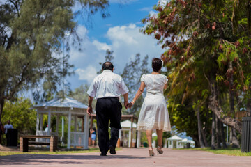 Couple of adults grandparents are walking on the park