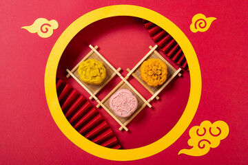 trendy flower shape mooncakes with Chinese style decorations on red background