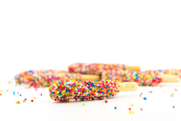 Fototapeta na wymiar bread sticks with rainbow sugar on white background